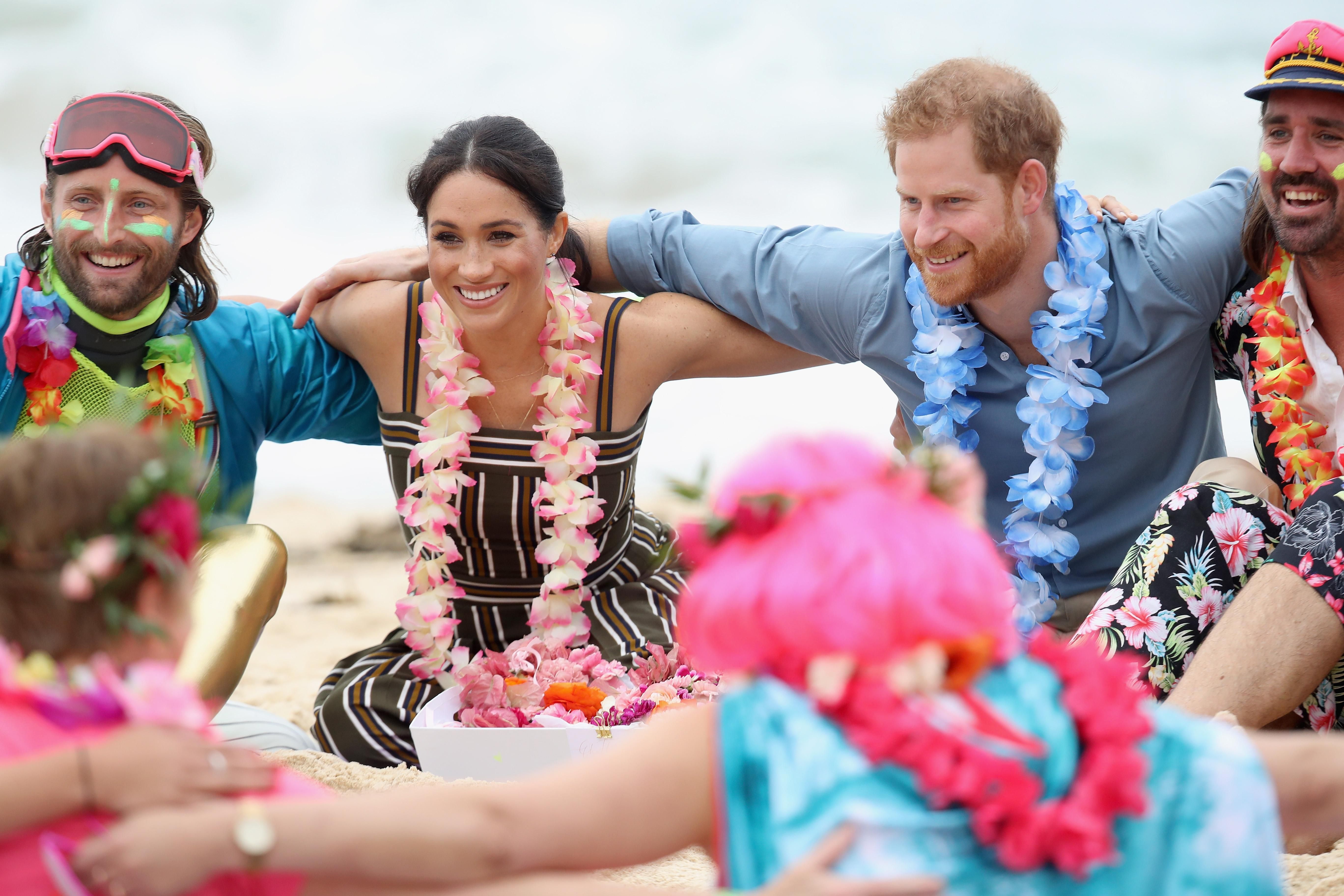 Гавайские бусы и сарафан в полоску: Меган Маркл и принц Гарри встретились с серферами на пляже