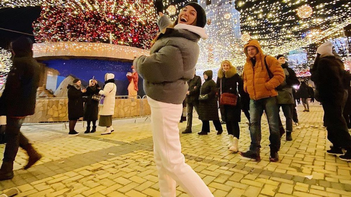 В короткой куртке и белых брюках: Кристина Решетник позировала возле елки в Киеве